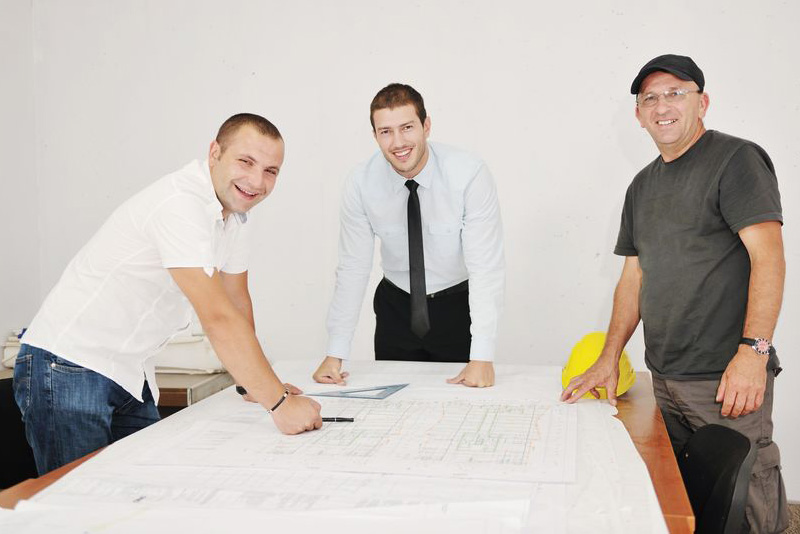 project management-team around desk smiling